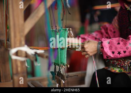 QIANDONGNAN, CHINA - 11. JANUAR 2022 - umgesiedelte Menschen weben traditionelle Miao-Kleiderschmuck, Southeast Guizhou Province, China, 11. Januar 202 Stockfoto