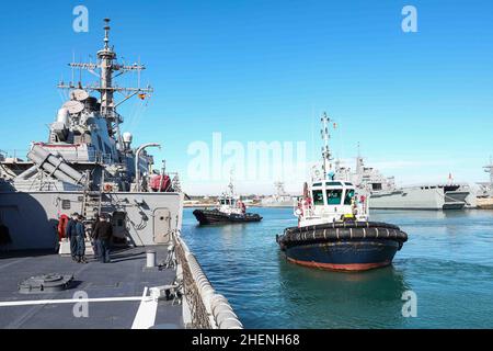 MARINESTÜTZPUNKT ROTA, Spanien (Jan 9, 2022) Schlepper ziehen sich vom Arleigh Burke-Klasse Lenkraketen-Zerstörer USS Ross (DDG 71) ab, nachdem sie das Schiff am 9. Januar 2022 in den Hafen der Marinestation Rota, Spanien, gebracht haben. Ross, der im spanischen Rota stationiert ist, ist auf seiner Patrouille 12th im Einsatzgebiet der Sechsten Flotte der USA, um regionale Verbündete und Partner sowie nationale Sicherheitsinteressen der USA in Europa und Afrika zu unterstützen. (USA Navy Foto von Mass Communication Specialist 2nd Class Claire DuBois/veröffentlicht) Stockfoto