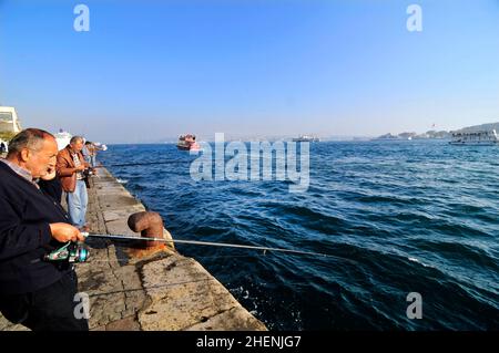 Türkische Männer fischen am Ufer des Goldenen Horns in Istanbul, Türkei. Stockfoto