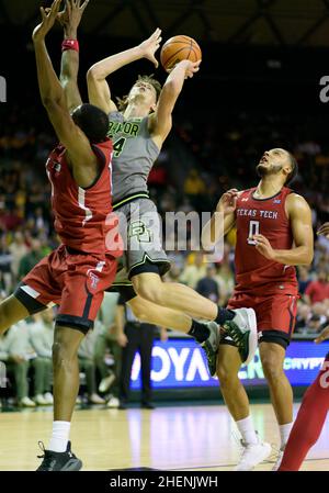 Waco, Texas, USA. 11th Januar 2022. Der Baylor Bears-Wächter Matthew Mayer (24) schießt den Ball gegen den Texas Tech Red Raiders-Stürmer Bryson Williams (11) während der 2nd-Halbzeit des NCAA-Basketballspiels zwischen den Texas Tech Red Raiders und Baylor Bears im Ferrell Center in Waco, Texas. Matthew Lynch/CSM/Alamy Live News Stockfoto