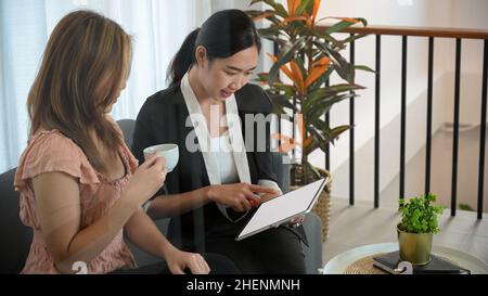 Eine asiatische Krankenversicherungsagentin, die ein privates Treffen mit ihrem Spezialkunden im Büro hat. Stockfoto