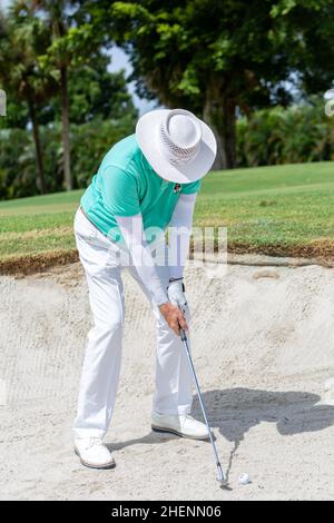 Golfspieler spielt ab. Mann, der Golfball vom Abschlagkasten im Golf Club in Miami, Florida, trifft. Golftour. Outdoor-Sportereignis. Stockfoto