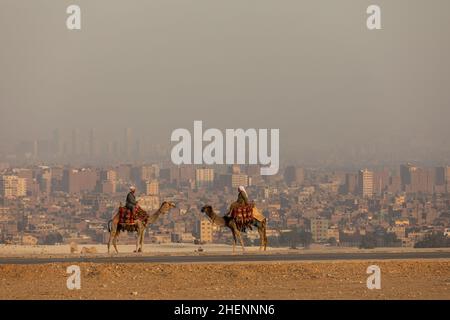 KAIRO, ÄGYPTEN, 17. NOVEMBER 2018: Zwei Kamelreiter stehen vor einander Stockfoto