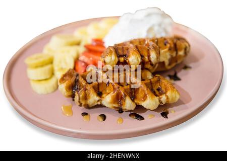 Draufsicht auf belgische Waffeln mit Schlagsahne und Bananenscheibe, Fokus selektiv Stockfoto