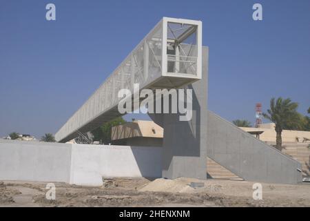 Fußgängerbrücke aus Stahl über den Al Khabeer Highway, Muharraq, Bahrain. Die Brücke ist Teil des Perling Trail von Bahrain, einem UNESCO-Weltkulturerbe Stockfoto