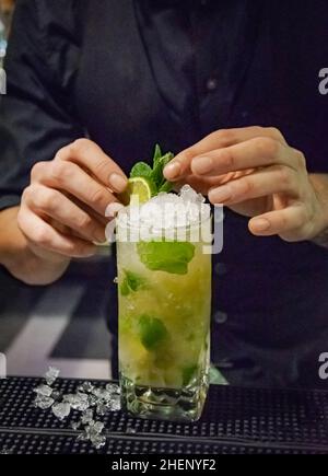 Ein Barkeeper macht einen erfrischenden Mojito-Cocktail in einem Nachtclub an der costa del sol Stockfoto