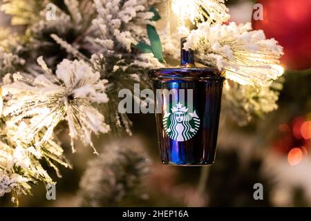 Während der Weihnachtszeit wird auf einem Weihnachtsbaum in einem Kaffeehaus ein Starbucks Weihnachtsordament gesehen. Stockfoto