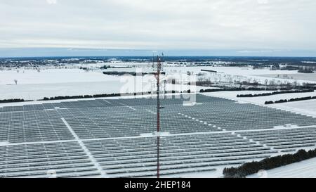 An einem schneebedeckten Wintertag ist eine Luftaufnahme von der Spitze eines Zellturms in einer ländlichen Gegend zu sehen. Stockfoto