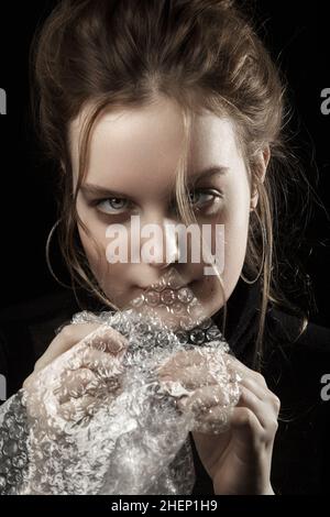 Gestresste Frau in Depression platzt Blasen der Verpackung Cellophan Stockfoto