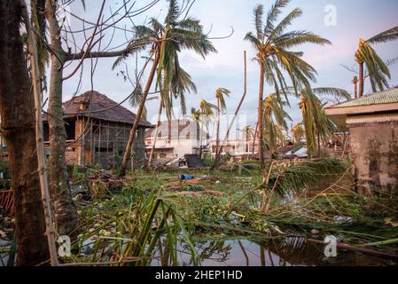 Siargao Insel am Tag nach dem zerstörerischen Taifun Odette, zerbrochene Häuser, umgestürzte Kokosnusspalmen, traurige Menschen, Sonnenaufgang und Straßen voller Müll Stockfoto