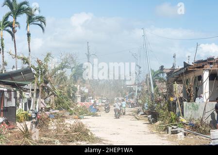 Siargao Insel am Tag nach dem zerstörerischen Taifun Odette, zerbrochene Häuser, umgestürzte Kokosnusspalmen, traurige Menschen, Sonnenaufgang und Straßen voller Müll Stockfoto