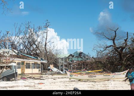 Siargao Insel am Tag nach dem zerstörerischen Taifun Odette, zerbrochene Häuser, umgestürzte Kokosnusspalmen, traurige Menschen, Sonnenaufgang und Straßen voller Müll Stockfoto