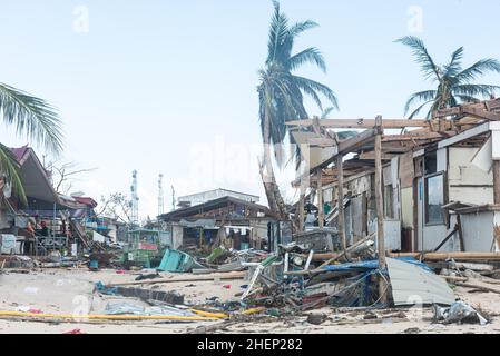 Siargao Insel am Tag nach dem zerstörerischen Taifun Odette, zerbrochene Häuser, umgestürzte Kokosnusspalmen, traurige Menschen, Sonnenaufgang und Straßen voller Müll Stockfoto