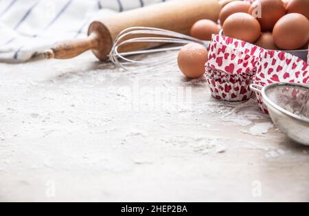 Backgeräte Eier Mehl und Cupcake-Etuis auf Küchentisch mit Platz zum Kopieren. Stockfoto