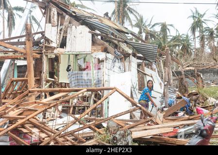 Siargao Insel am Tag nach dem zerstörerischen Taifun Odette, zerbrochene Häuser, umgestürzte Kokosnusspalmen, traurige Menschen, Sonnenaufgang und Straßen voller Müll Stockfoto