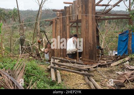 Siargao Insel am Tag nach dem zerstörerischen Taifun Odette, zerbrochene Häuser, umgestürzte Kokosnusspalmen, traurige Menschen, Sonnenaufgang und Straßen voller Müll Stockfoto