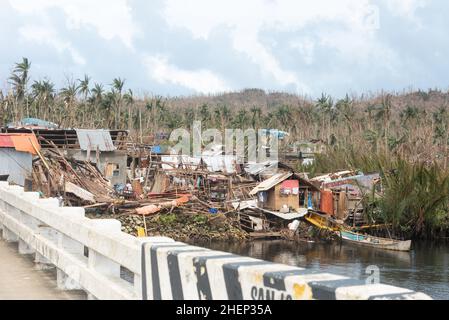 Siargao Insel am Tag nach dem zerstörerischen Taifun Odette, zerbrochene Häuser, umgestürzte Kokosnusspalmen, traurige Menschen, Sonnenaufgang und Straßen voller Müll Stockfoto