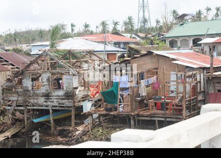 Siargao Insel am Tag nach dem zerstörerischen Taifun Odette, zerbrochene Häuser, umgestürzte Kokosnusspalmen, traurige Menschen, Sonnenaufgang und Straßen voller Müll Stockfoto