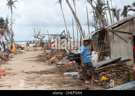 Siargao Insel am Tag nach dem zerstörerischen Taifun Odette, zerbrochene Häuser, umgestürzte Kokosnusspalmen, traurige Menschen, Sonnenaufgang und Straßen voller Müll Stockfoto