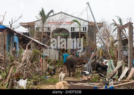 Siargao Insel am Tag nach dem zerstörerischen Taifun Odette, zerbrochene Häuser, umgestürzte Kokosnusspalmen, traurige Menschen, Sonnenaufgang und Straßen voller Müll Stockfoto