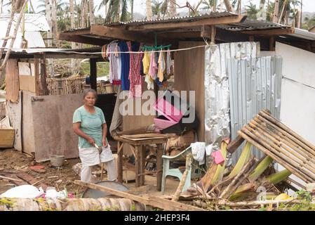 Siargao Insel am Tag nach dem zerstörerischen Taifun Odette, zerbrochene Häuser, umgestürzte Kokosnusspalmen, traurige Menschen, Sonnenaufgang und Straßen voller Müll Stockfoto