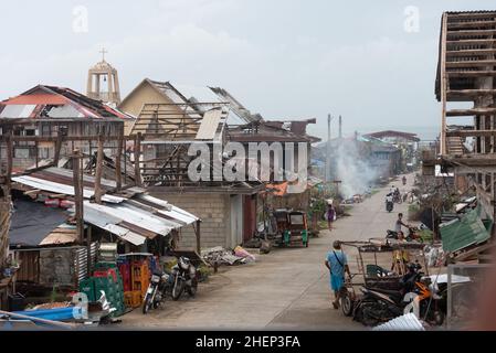Siargao Insel am Tag nach dem zerstörerischen Taifun Odette, zerbrochene Häuser, umgestürzte Kokosnusspalmen, traurige Menschen, Sonnenaufgang und Straßen voller Müll Stockfoto