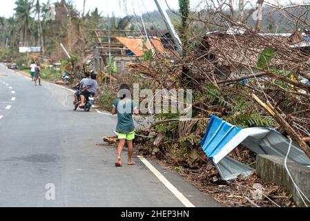 Siargao Insel am Tag nach dem zerstörerischen Taifun Odette, zerbrochene Häuser, umgestürzte Kokosnusspalmen, traurige Menschen, Sonnenaufgang und Straßen voller Müll Stockfoto