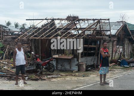 Siargao Insel am Tag nach dem zerstörerischen Taifun Odette, zerbrochene Häuser, umgestürzte Kokosnusspalmen, traurige Menschen, Sonnenaufgang und Straßen voller Müll Stockfoto