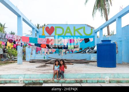 Siargao Insel am Tag nach dem zerstörerischen Taifun Odette, zerbrochene Häuser, umgestürzte Kokosnusspalmen, traurige Menschen, Sonnenaufgang und Straßen voller Müll Stockfoto