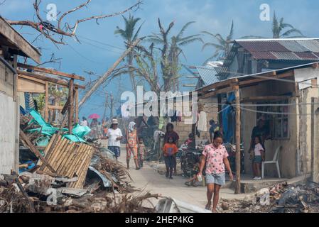 Siargao Insel am Tag nach dem zerstörerischen Taifun Odette, zerbrochene Häuser, umgestürzte Kokosnusspalmen, traurige Menschen, Sonnenaufgang und Straßen voller Müll Stockfoto