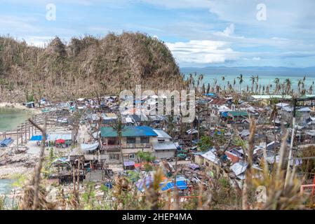Siargao Insel am Tag nach dem zerstörerischen Taifun Odette, zerbrochene Häuser, umgestürzte Kokosnusspalmen, traurige Menschen, Sonnenaufgang und Straßen voller Müll Stockfoto