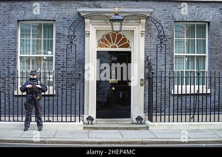 Ein Polizeibeamter steht vor der Tür des offiziellen Wohnsitzes des Premierministers in Downing Street, Westminster, London, während die öffentliche Wut nach dem Leck am Montag einer E-Mail von Boris Johnsons wichtigster Privatsekretär Martin Reynolds weiter anhält. Laden Sie 100 Mitarbeiter der Downing Street zu einer „Bring Your Own Booze“-Party im Garten hinter der Nummer 10 während der ersten englischen Sperre am 20. Mai 2020 ein. Bilddatum: Mittwoch, 12. Januar 2022. Stockfoto