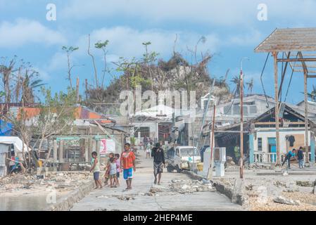 Siargao Insel am Tag nach dem zerstörerischen Taifun Odette, zerbrochene Häuser, umgestürzte Kokosnusspalmen, traurige Menschen, Sonnenaufgang und Straßen voller Müll Stockfoto