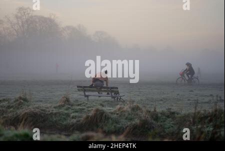 Wimbledon, London, Großbritannien. 12. Januar 2022. Menschen, die pendeln und sich fit halten, werden im Morgennebel auf dem Wimbledon Common in den Vororten im Südwesten Londons im Morgengrauen beobachtet. Quelle: Malcolm Park/Alamy Live News. Stockfoto