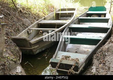 Zwei grüne Kanus liegen im Fluss am Wasser. Stockfoto