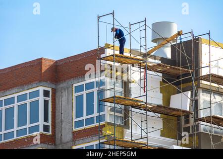 Abschluss mit Mineral- und Polystyroldämmung der Fassade eines im Bau befindlichen Wohngebäudes, selektiver Fokus Stockfoto