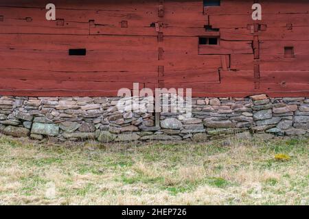 Alte rote Scheune mit Holzwerk auf einer Graswiese Stockfoto