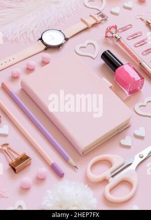 Pinke Papierkarte mit Clip, schulische Accessoires und Herzen auf pastellrosa Nahaufnahme, leeres Kartenmockup. Mädchenarbeitsplatz. Zurück in die Schule und Valen Stockfoto