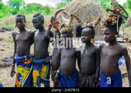 Mursi People Kinder in Nationalkostümen im Stammdorf Stockfoto