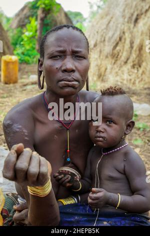 Mursi Menschen Frauen mit Baby im Stammdorf Stockfoto