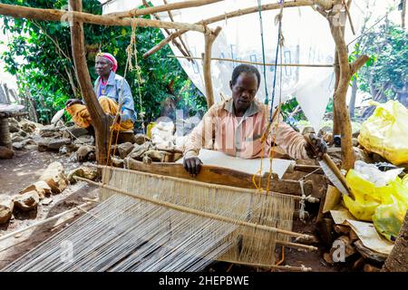 Afrikanischer Konso-Mann dreht sich mit den Händen auf dem Holzrad im lokalen Stammesdorf Stockfoto