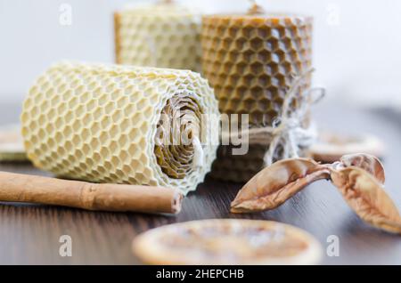 Handgemachte Wachskerzen mit Honigaroma auf dunklem Holzhintergrund Stockfoto