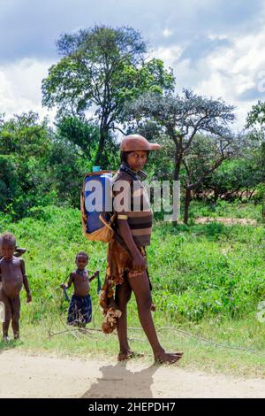 Müde Hamer Tribe Frauen kommen von Farm Work von der Grünen Landstraße zurück Stockfoto