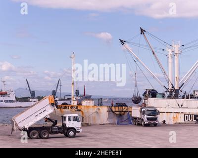 Thunfisch-Shuttle-Schiff, das Gelbflossen-Thunfisch auf wartende Lastwagen im Fischereihafen in General Santos City auf den Philippinen entlädt. Die Shuttle-Schiffe Stockfoto