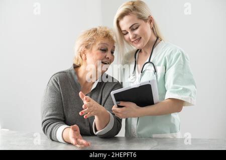 Krankenschwester, die ältere Frau Presciption verleihen Stockfoto