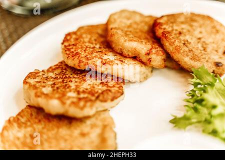 Kartoffelpfannkuchen oder Draniki oder Latkes auf einem Teller in einem Restaurant. Traditionelle Kartoffelgerichte und Speisen in Osteuropa und Israel. Hochwertige Fotos Stockfoto