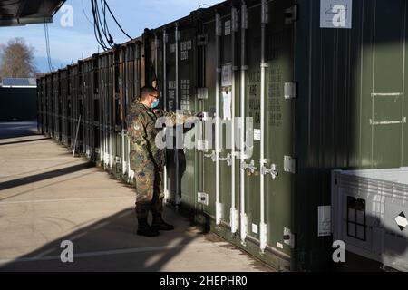 11. Januar 2022, Niedersachsen, Quakenbrück: Duane-Eddy Harder, Senior Field Pharmacist, steht vor Kühlcontainern für Impfstoffe. Die Apotheke der Bundeswehr in der Artland-Kaserne hat bereits rund 100 Millionen Impfdosen abgefertigt. Seit letztem Jahr werden in Deutschland Corona-Impfdosen aus den Artland-Kasernen im Landkreis Osnabrück verteilt. Foto: Friso Gentsch/dpa Stockfoto