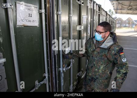 11. Januar 2022, Niedersachsen, Quakenbrück: Duane-Eddy Harder, Senior Field Pharmacist, steht vor einem Kühlcontainer für Impfstoffe. Die Apotheke der Bundeswehr in der Artland-Kaserne hat bereits rund 100 Millionen Impfdosen abgefertigt. Seit letztem Jahr werden in Deutschland Corona-Impfdosen aus den Artland-Kasernen im Landkreis Osnabrück verteilt. Foto: Friso Gentsch/dpa Stockfoto