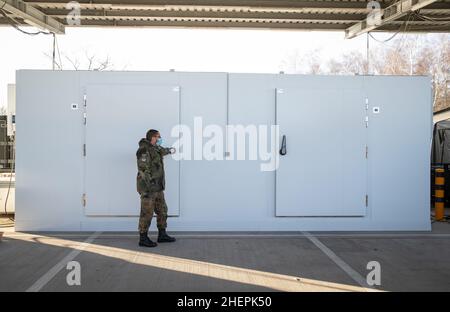 11. Januar 2022, Niedersachsen, Quakenbrück: Duane-Eddy Harder, Senior Field Pharmacist, steht vor einem Kühlcontainer für Impfstoffe. Die Apotheke der Bundeswehr in der Artland-Kaserne hat bereits rund 100 Millionen Impfdosen abgefertigt. Seit letztem Jahr werden in Deutschland Corona-Impfdosen aus den Artland-Kasernen im Landkreis Osnabrück verteilt. Foto: Friso Gentsch/dpa Stockfoto