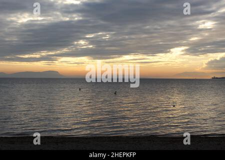 Sonnenuntergang über dem Genfer See. Wolkiger Sonnenuntergang mit Bergsilhouetten am Horizont (Schweiz) Stockfoto